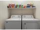Laundry room equipped with a washer, dryer, and ample shelving for storage at 14821 W Honeysuckle Ln, Surprise, AZ 85374