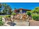 Charming home exterior with a unique rock waterfall feature and mature trees at 1550 N Stapley Dr # 95, Mesa, AZ 85203