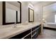 Bright bathroom with a double sink vanity, framed mirrors, and convenient access to the main bedroom at 18130 N 92Nd Ln, Peoria, AZ 85382
