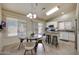 Sunlit kitchen with white cabinetry, stainless appliances, a peninsula, and adjacent breakfast nook at 18130 N 92Nd Ln, Peoria, AZ 85382