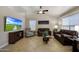Cozy living room featuring tile flooring, a ceiling fan, and lots of natural light at 18130 N 92Nd Ln, Peoria, AZ 85382