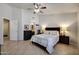 Spacious main bedroom with ceiling fan, decorative lighting, and doorway to bathroom at 18130 N 92Nd Ln, Peoria, AZ 85382