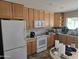 Functional kitchen with wooden cabinets and white appliances, needs renovation at 1843 S Papago Dr, Apache Junction, AZ 85120