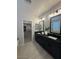 Modern bathroom with dual sinks, granite countertop, black cabinetry, and a large walk-in closet at 18941 W Monterosa St, Litchfield Park, AZ 85340