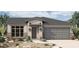 Charming single-story home featuring a desert landscape, stone accents, and a two-car garage at 19317 W San Juan Ave, Litchfield Park, AZ 85340