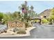 Landscaped entrance to Troon community with guard house, mature desert landscaping and an American flag at 25150 N Windy Walk Dr # 14, Scottsdale, AZ 85255