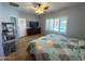 Bedroom with wooden floors, ceiling fan and a view of the backyard pool at 26243 W Wahalla Ln, Buckeye, AZ 85396