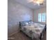 Bright bedroom with wood floors, ceiling fan and a stylish accent wall at 26243 W Wahalla Ln, Buckeye, AZ 85396
