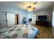 Spacious bedroom with wood floors, ceiling fan, and access to another room at 26243 W Wahalla Ln, Buckeye, AZ 85396
