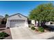 Charming single-story home featuring a two-car garage, desert landscaping, and a well-maintained front yard at 26243 W Wahalla Ln, Buckeye, AZ 85396