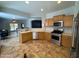 Bright kitchen features stainless steel appliances, wood cabinets, and tile flooring at 26243 W Wahalla Ln, Buckeye, AZ 85396