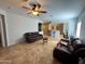 Bright and open living area with tile floors, ceiling fan, and a breakfast bar looking into the kitchen at 26243 W Wahalla Ln, Buckeye, AZ 85396