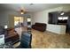Open-concept living room featuring tile flooring, ceiling fans, and sliding glass doors to the backyard pool at 26243 W Wahalla Ln, Buckeye, AZ 85396
