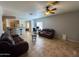 Spacious living area with tile floors, ceiling fan, and an open layout with views into the kitchen at 26243 W Wahalla Ln, Buckeye, AZ 85396
