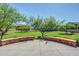Lush green common area with trees and manicured landscaping, viewed from a concrete patio with brick accents at 2725 E Mine Creek Rd # 2146, Phoenix, AZ 85024