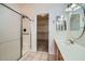 Well-lit bathroom features a tiled shower with glass door, single vanity, and access to walk-in closet at 2729 N Kenton St, Mesa, AZ 85215