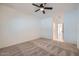 Bedroom with neutral carpet, ceiling fan, and open view into hallway with bathroom and closet at 2729 N Kenton St, Mesa, AZ 85215