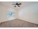 Bedroom featuring neutral carpet, ceiling fan and arched window for plenty of natural light at 2729 N Kenton St, Mesa, AZ 85215
