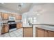 Bright kitchen featuring wood cabinets, white appliances, and an open view to the living area at 2729 N Kenton St, Mesa, AZ 85215