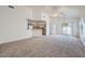 Open-concept living room with neutral carpet, ceiling fan, and sliding glass doors to the backyard at 2729 N Kenton St, Mesa, AZ 85215