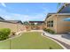 Inviting backyard space featuring an outdoor kitchen, putting green, and landscaped yard at 3058 E Spring Wheat Ln, Gilbert, AZ 85296