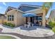 Charming backyard patio with stone pavers, an umbrella-covered dining set, and mature landscaping at 3058 E Spring Wheat Ln, Gilbert, AZ 85296