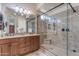 Modern bathroom featuring granite counters, dual sinks, and a large glass-enclosed shower with built-in bench at 3058 E Spring Wheat Ln, Gilbert, AZ 85296