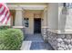 Charming front entrance showcasing stone accents, a covered porch, and a stylish black front door at 3058 E Spring Wheat Ln, Gilbert, AZ 85296