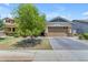 Inviting single-Gathering home with a well-maintained front yard and a charming, tree-lined paver driveway at 3058 E Spring Wheat Ln, Gilbert, AZ 85296