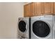 Functional laundry room featuring a side-by-side washer and dryer set and upper cabinets at 3058 E Spring Wheat Ln, Gilbert, AZ 85296