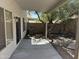 View of a shaded back patio with door and windows and a large shade tree at 3428 E Renee Dr, Phoenix, AZ 85050