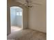 Bedroom with neutral carpet, ceiling fan, and an arched doorway to a connected room at 3428 E Renee Dr, Phoenix, AZ 85050