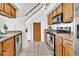 Kitchen featuring stainless steel appliances, wooden cabinets, and staircase that adds architectural interest at 3855 W Denver St, Chandler, AZ 85226