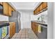 Open-concept kitchen featuring stainless steel appliances, wooden cabinets, and neutral flooring at 3855 W Denver St, Chandler, AZ 85226