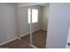 Bedroom includes mirrored closet doors, carpeted floor, and a view through a window of an exterior scene at 413 E Bruce Ave # D, Gilbert, AZ 85234