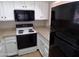 Bright kitchen with white cabinets, tan countertops, and updated black appliances at 413 E Bruce Ave # D, Gilbert, AZ 85234
