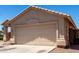 Tan home showing the garage and driveway with desert landscaping at 4942 W Novak Way, Laveen, AZ 85339