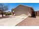 Tan home showing the garage and driveway with desert landscaping at 4942 W Novak Way, Laveen, AZ 85339