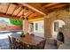 Covered patio featuring a brick fireplace, dining table, and wood beamed ceiling perfect for outdoor gatherings at 5112 N 32Nd Pl, Phoenix, AZ 85018