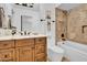 Bathroom with marble countertop sink, stylish fixtures, and tiled shower-bath combo at 5320 W Soft Wind Dr, Glendale, AZ 85310