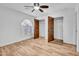 A well-lit bedroom featuring wood-look floors and a view of the closet space at 5320 W Soft Wind Dr, Glendale, AZ 85310