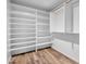 Spacious walk-in closet featuring custom shelving and wood floors at 5320 W Soft Wind Dr, Glendale, AZ 85310