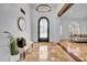 Inviting foyer featuring tile flooring, a decorative iron door, and elegant lighting at 5320 W Soft Wind Dr, Glendale, AZ 85310