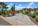Expansive circular driveway leads to a beautifully landscaped home with desert plants and mature trees at 5320 W Soft Wind Dr, Glendale, AZ 85310
