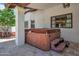 Outdoor hot tub under a covered patio with stone flooring and lush surroundings at 5320 W Soft Wind Dr, Glendale, AZ 85310