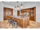 Gourmet kitchen with a large island, custom wood cabinetry, stone countertops, and pendant lighting at 5320 W Soft Wind Dr, Glendale, AZ 85310