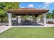 An outdoor covered patio with a built-in grill, dining table, and a swing offers an inviting space for gatherings at 5320 W Soft Wind Dr, Glendale, AZ 85310