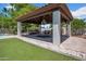 An outdoor covered patio with a built-in grill, dining table, and a swing offers an inviting space for gatherings at 5320 W Soft Wind Dr, Glendale, AZ 85310