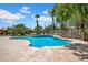 Private swimming pool with stone decking, lush palm trees, and secure fencing at 5320 W Soft Wind Dr, Glendale, AZ 85310
