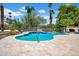 A private pool surrounded by travertine tile offers a refreshing retreat with lush landscaping and mature palm trees at 5320 W Soft Wind Dr, Glendale, AZ 85310
